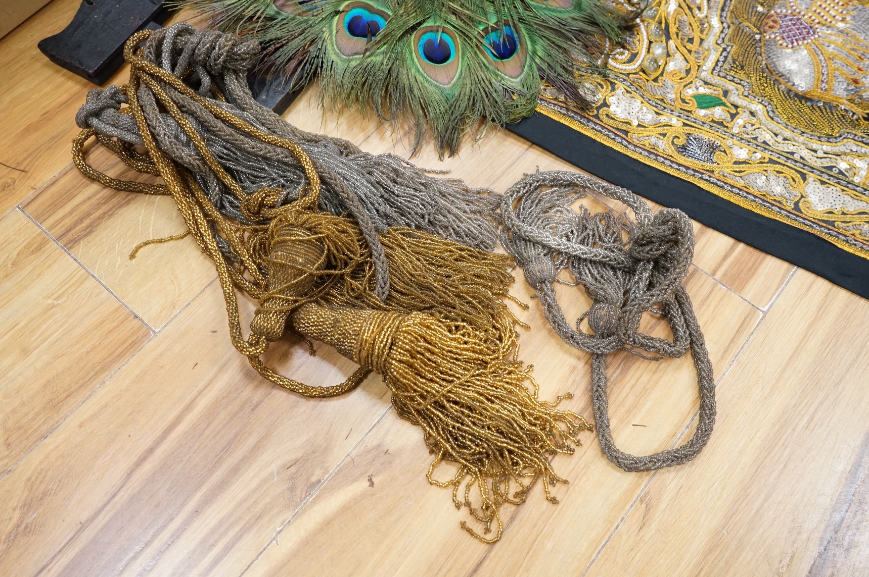 A quantity of mostly 20th century Middle Eastern and Indian woven and printed textiles and a peacock feather fan (2 boxes).